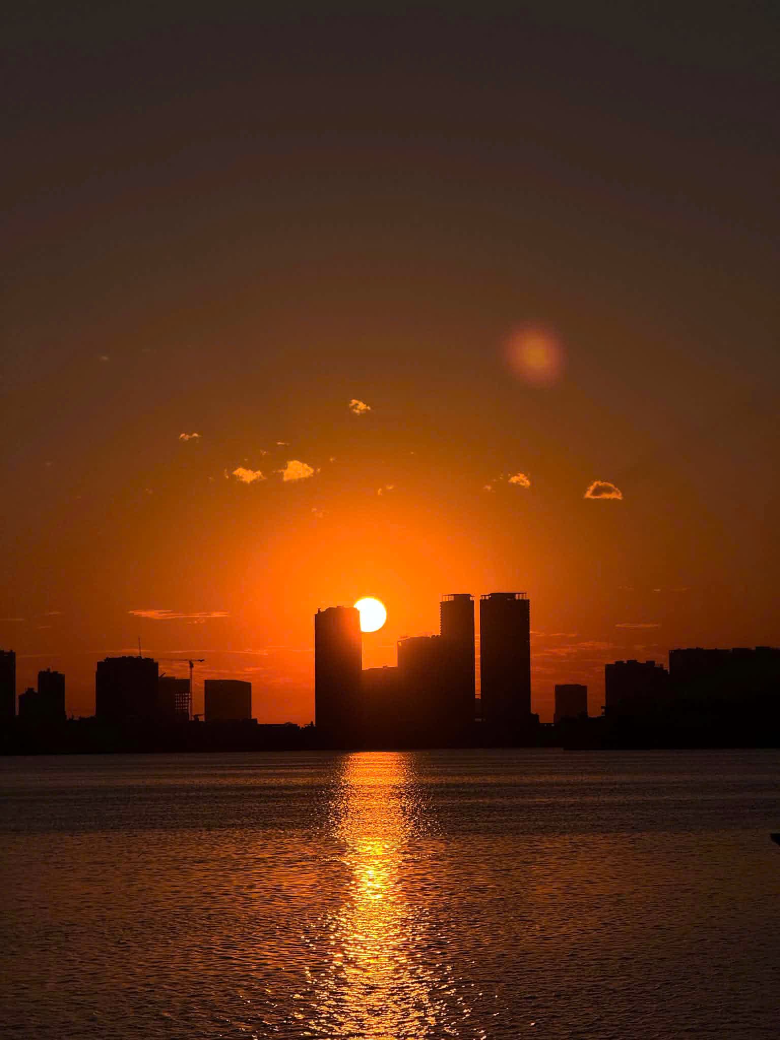 Danang's skyline silhouetted against a molten sunset over the river
